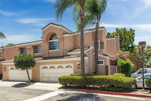 12152 Napoli Dr, Cerritos, CA 90703 - mediterranean / spanish home with stucco siding, a tiled roof, concrete driveway, and an attached garage