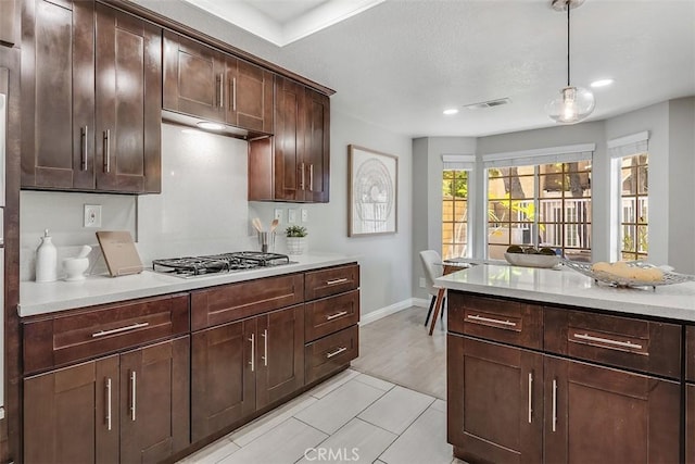 12152 Napoli Dr, Cerritos, CA 90703 - kitchen featuring stainless steel gas stovetop, light countertops, hanging light fixtures, dark brown cabinets, and recessed lighting