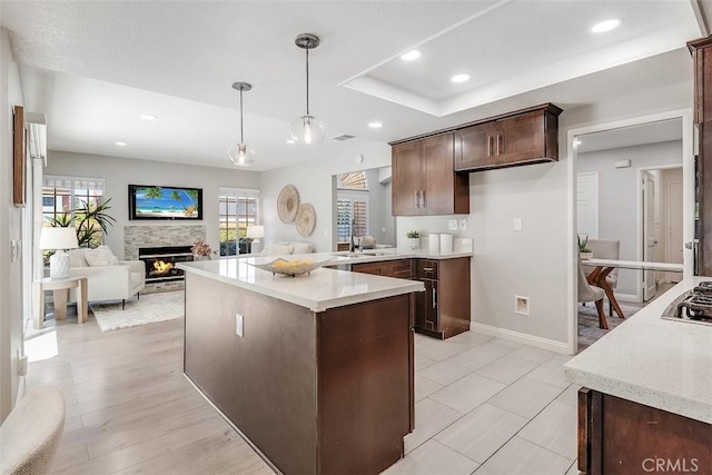 12152 Napoli Dr, Cerritos, CA 90703 - kitchen with a stone fireplace, dark brown cabinets, pendant lighting, recessed lighting, and open floor plan