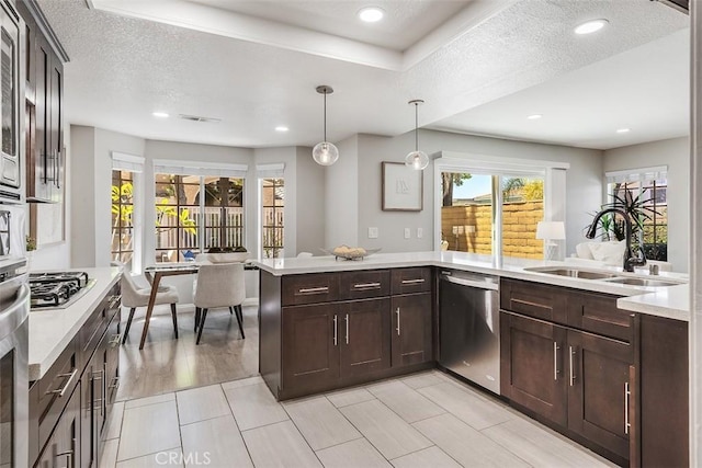 12152 Napoli Dr, Cerritos, CA 90703 - kitchen with stainless steel appliances, light countertops, dark brown cabinets, decorative light fixtures, and recessed lighting
