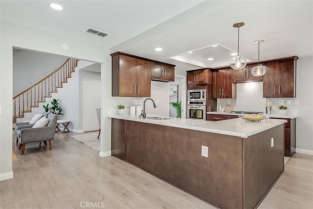 12152 Napoli Dr, Cerritos, CA 90703 - kitchen with stainless steel appliances, light wood-type flooring, light countertops, a peninsula, and recessed lighting