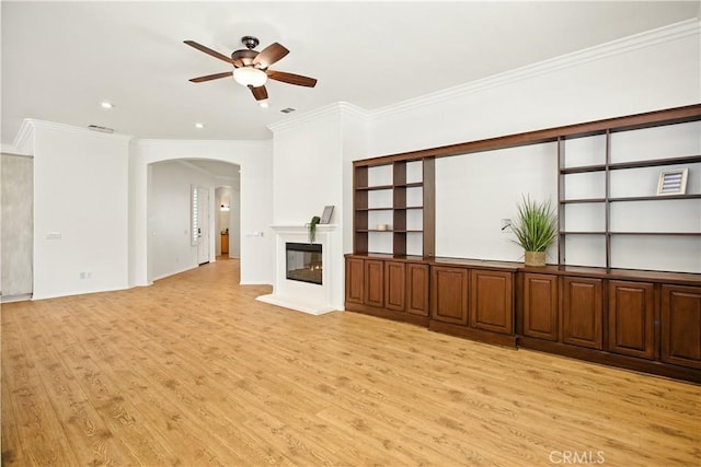 1740 Las Colinas Rd, Beaumont, CA 92223 - unfurnished living room with arched walkways, light wood-type flooring, ceiling fan, a glass covered fireplace, and ornamental molding