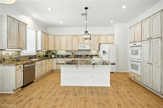 1740 Las Colinas Rd, Beaumont, CA 92223 - kitchen with white appliances, a center island, dark stone counters, decorative backsplash, and crown molding