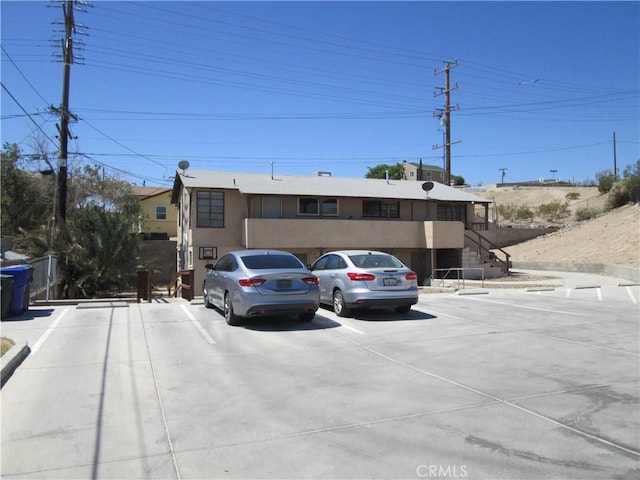 201 W Williams St, Barstow, CA 92311 - exterior space with stairway, uncovered parking, and stucco siding