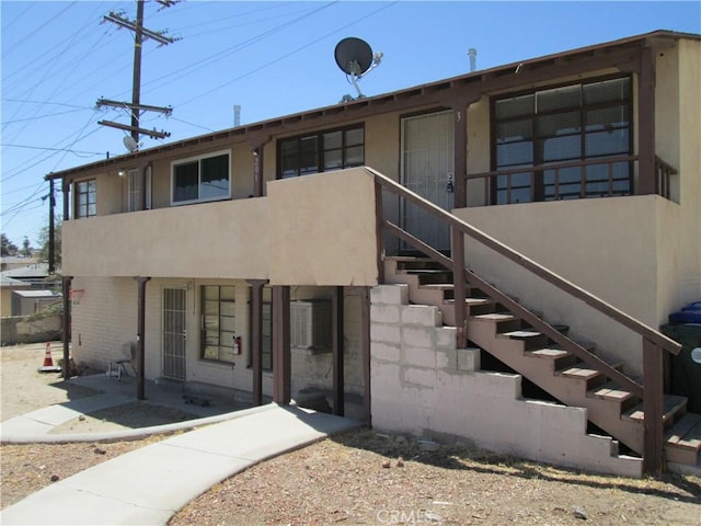 201 W Williams St, Barstow, CA 92311 - rear view of house featuring stucco siding and stairs