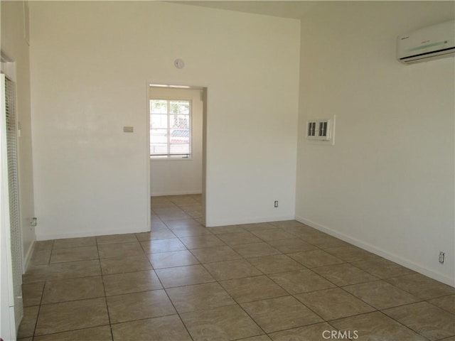 201 W Williams St, Barstow, CA 92311 - tiled empty room featuring a wall unit AC and baseboards