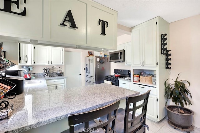 10000 8th Ave, Hesperia, CA 92345 - kitchen with stainless steel appliances, a peninsula, light stone counters, and white cabinets
