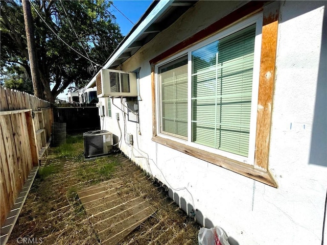 1325 Norton Ave, Dos Palos, CA 93620 - view of home's exterior featuring a fenced backyard, stucco siding, and a wall mounted air conditioner