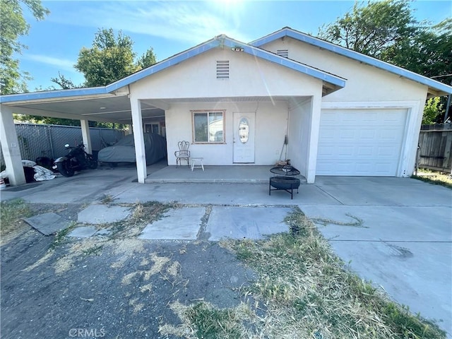 1325 Norton Ave, Dos Palos, CA 93620 - view of front of home with concrete driveway, stucco siding, covered porch, and a garage