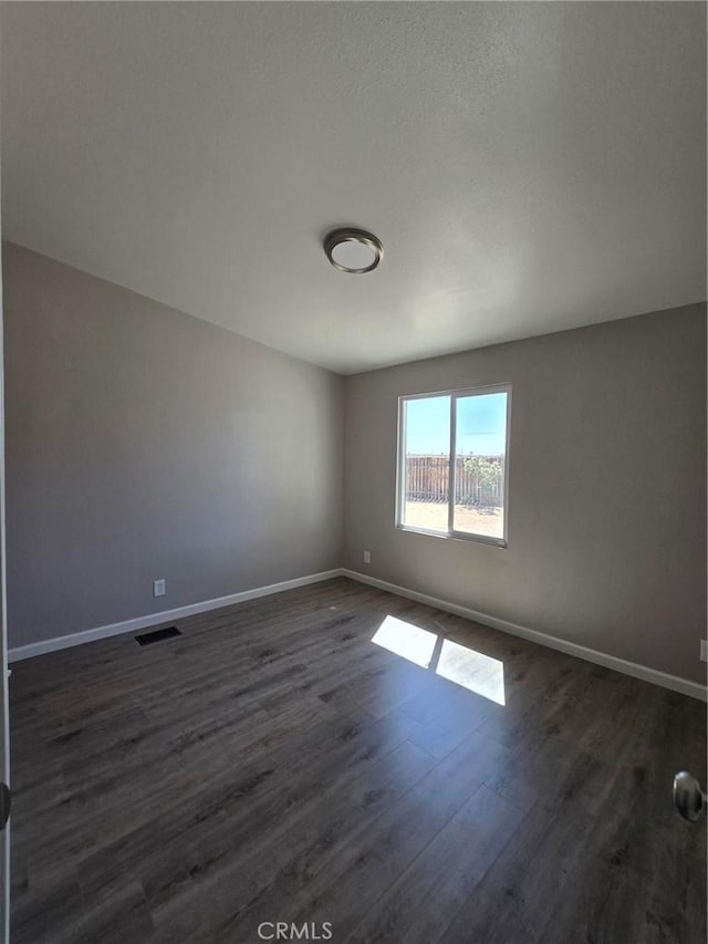 18812 Arbor Ct, Adelanto, CA 92301 - empty room featuring baseboards and dark wood-style flooring