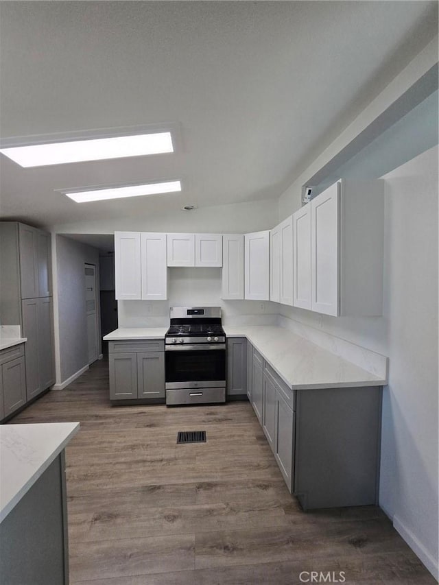 18812 Arbor Ct, Adelanto, CA 92301 - kitchen featuring gas range, gray cabinetry, wood finished floors, and light countertops