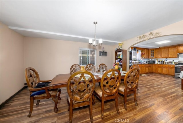 795 E 42nd Pl, Los Angeles, CA 90011 - dining area with arched walkways, wood finished floors, and a chandelier