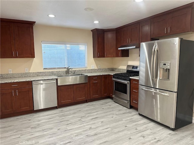 350 E 223rd St, Carson, CA 90745 - kitchen with appliances with stainless steel finishes, light wood-style flooring, under cabinet range hood, recessed lighting, and light stone countertops