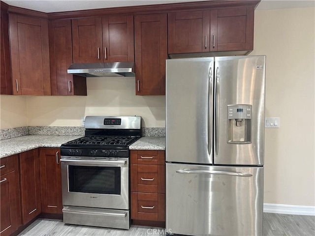 350 E 223rd St, Carson, CA 90745 - kitchen featuring stainless steel appliances, under cabinet range hood, light wood finished floors, and light stone countertops