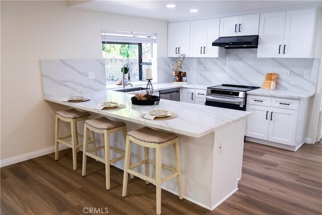 12 Ninos, Irvine, CA 92620 - kitchen with electric range, extractor fan, a peninsula, wood finished floors, and recessed lighting