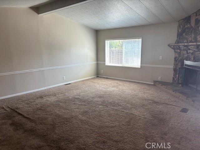 10220 Wrangler Way, Corona, CA 92883 - unfurnished living room with carpet floors and a stone fireplace