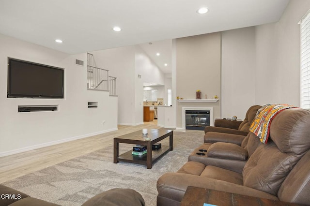 1531 Daphne Ave, Ventura, CA 93004 - living area featuring wood finished floors, recessed lighting, stairway, a glass covered fireplace, and vaulted ceiling