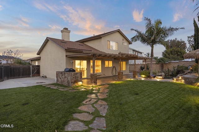1531 Daphne Ave, Ventura, CA 93004 - back of property at dusk with a patio, a fenced backyard, stucco siding, and a chimney