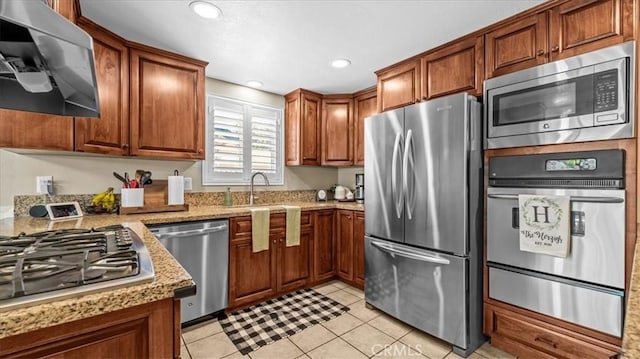 1052 Golden Rain St, Upland, CA 91786 - kitchen with appliances with stainless steel finishes, a warming drawer, ventilation hood, light tile patterned flooring, and brown cabinetry