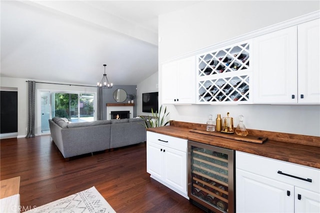 348 Clubhouse Dr, Santa Maria, CA 93455 - indoor dry bar with beverage cooler, vaulted ceiling, dark wood-style floors, a lit fireplace, and a chandelier