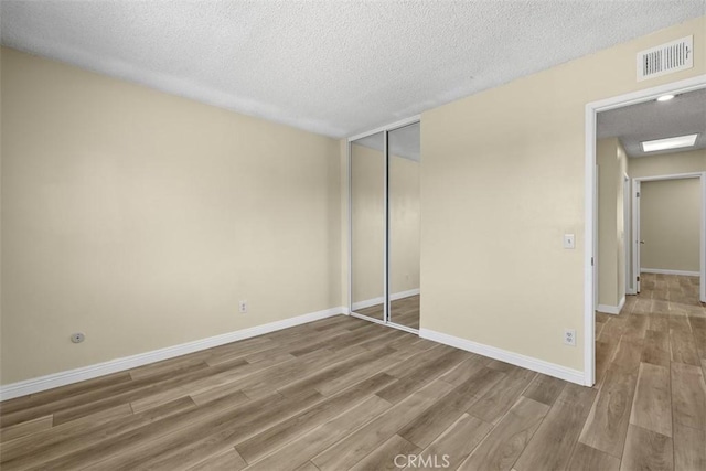 3262 Avenida Simi, Simi Valley, CA 93063 - unfurnished bedroom with wood finished floors, a closet, and a textured ceiling