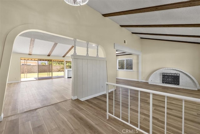 3262 Avenida Simi, Simi Valley, CA 93063 - unfurnished living room featuring wood finished floors, a brick fireplace, and arched walkways