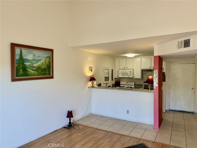 7640 Oso Ave Unit 316, Winnetka, CA 91306 - kitchen featuring white appliances, light wood-type flooring, and white cabinets
