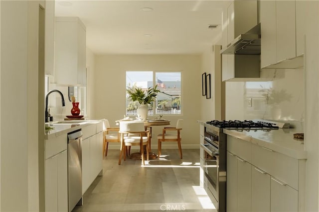 722 W Cully Dr, Orange, CA 92865 - kitchen with stainless steel appliances, under cabinet range hood, light countertops, and white cabinetry