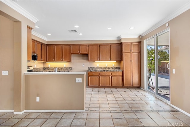 31241 Casera Ct, Menifee, CA 92584 - kitchen featuring ornamental molding, stainless steel microwave, brown cabinetry, recessed lighting, and a peninsula