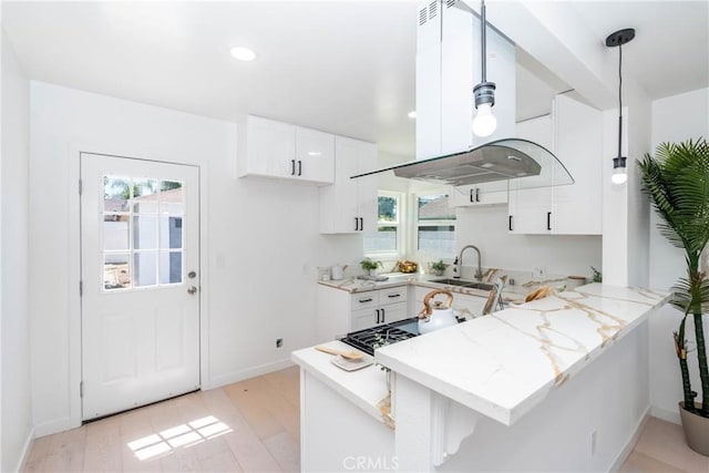 8168 Summerfield Ave, Whittier, CA 90606 - kitchen featuring island range hood, a peninsula, light stone countertops, white cabinetry, and light wood-type flooring