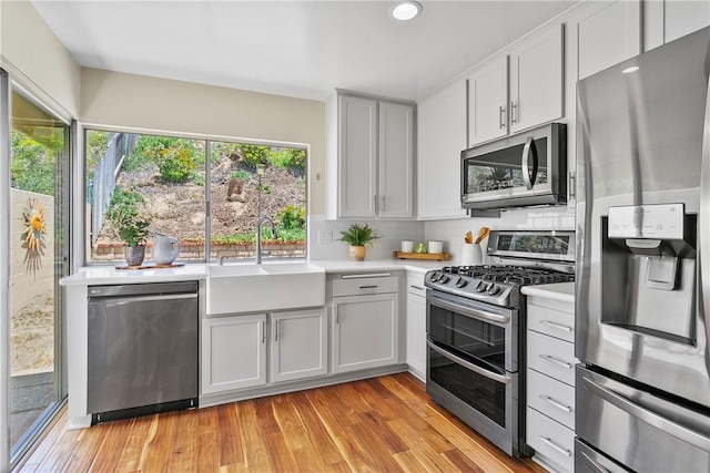 26551 Fresno Dr, Mission Viejo, CA 92691 - kitchen with appliances with stainless steel finishes, light countertops, tasteful backsplash, light wood-type flooring, and recessed lighting