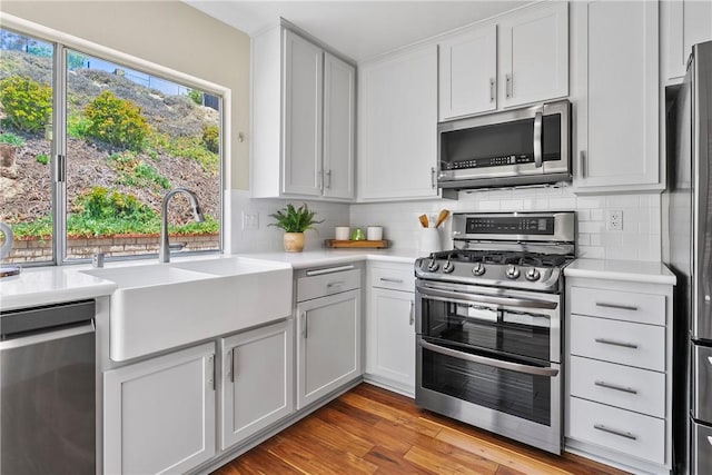 26551 Fresno Dr, Mission Viejo, CA 92691 - kitchen with appliances with stainless steel finishes, light countertops, backsplash, light wood-style flooring, and white cabinetry