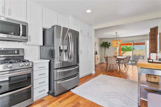 26551 Fresno Dr, Mission Viejo, CA 92691 - kitchen with appliances with stainless steel finishes, white cabinetry, light wood-type flooring, tasteful backsplash, and recessed lighting