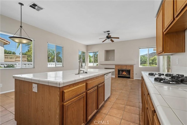 42730 Settlers Rdg, Murrieta, CA 92562 - kitchen with white appliances, tile counters, light tile patterned floors, a fireplace, and a ceiling fan