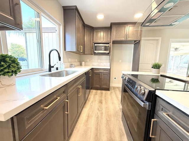 9944 Donner St, Santee, CA 92071 - kitchen with range with electric cooktop, range hood, stainless steel microwave, light wood-style floors, and healthy amount of natural light