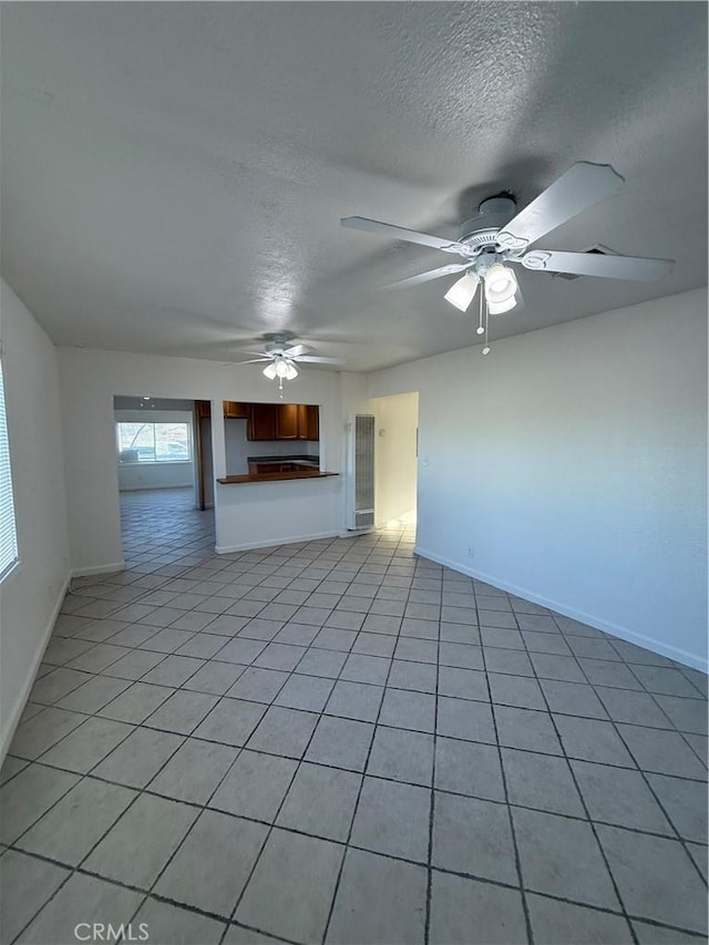 1032 W Coronado Ave, Ridgecrest, CA 93555 - unfurnished living room with a textured ceiling, ceiling fan, and light tile patterned floors