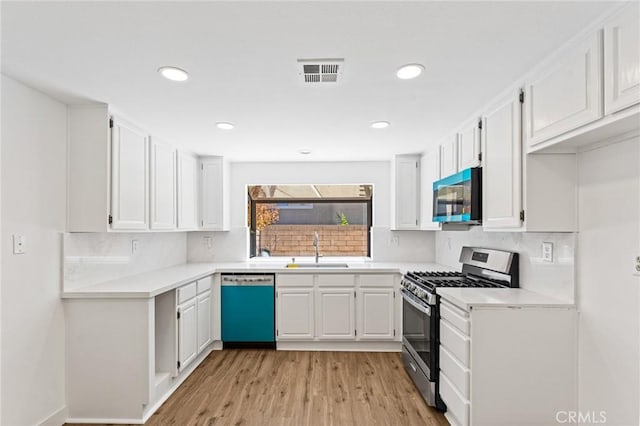 25632 Seaside Dr Unit 140, Dana Point, CA 92629 - kitchen with appliances with stainless steel finishes, light wood-style flooring, backsplash, white cabinets, and recessed lighting
