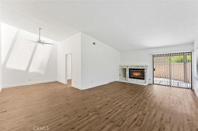 25632 Seaside Dr Unit 140, Dana Point, CA 92629 - unfurnished living room featuring wood finished floors, lofted ceiling, a glass covered fireplace, and a ceiling fan
