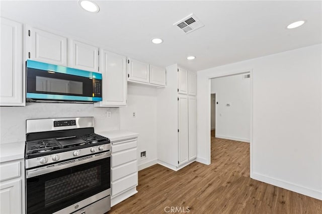 25632 Seaside Dr Unit 140, Dana Point, CA 92629 - kitchen with appliances with stainless steel finishes, light countertops, light wood-style flooring, white cabinetry, and recessed lighting
