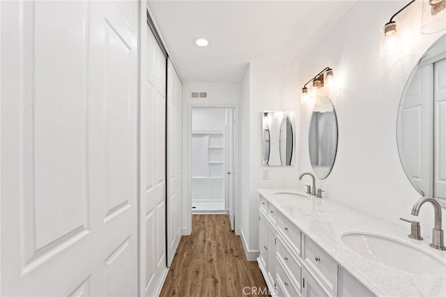 25632 Seaside Dr Unit 140, Dana Point, CA 92629 - bathroom featuring a closet, double vanity, wood finished floors, and recessed lighting
