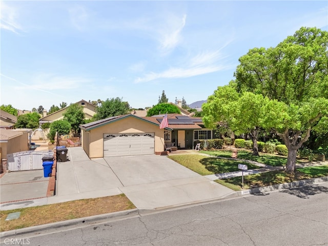 7420 London Ave, Rancho Cucamonga, CA 91730 - ranch-style home featuring a gate, concrete driveway, solar panels, a garage, and stucco siding
