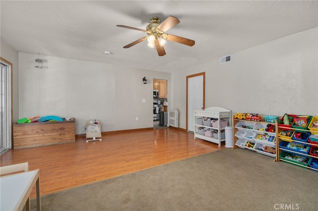 7420 London Ave, Rancho Cucamonga, CA 91730 - recreation room with ceiling fan, carpet, wood finished floors, and a textured ceiling