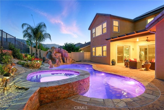 11905 Flicker Cv, Corona, CA 92883 - pool at dusk with a fenced backyard, ceiling fan, a pool with connected hot tub, and a patio