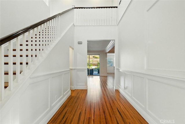11905 Flicker Cv, Corona, CA 92883 - stairs featuring a decorative wall, wood finished floors, a wainscoted wall, and a high ceiling