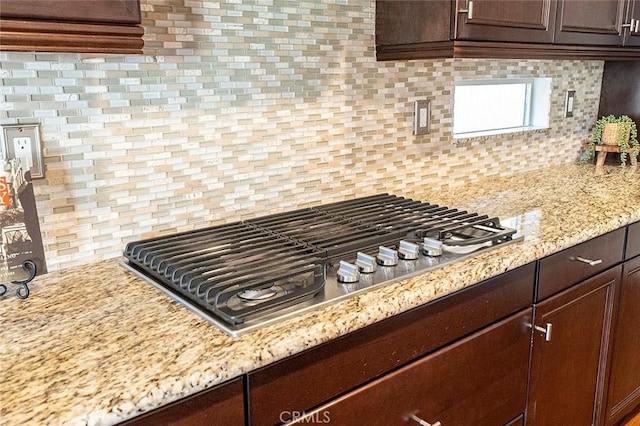 11905 Flicker Cv, Corona, CA 92883 - kitchen with stainless steel gas cooktop, dark brown cabinets, and tasteful backsplash