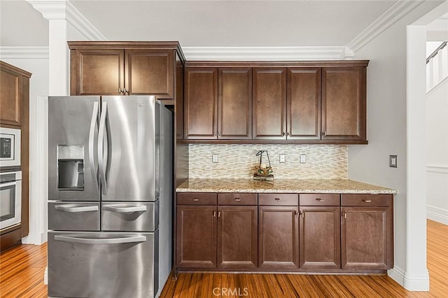 11905 Flicker Cv, Corona, CA 92883 - kitchen featuring appliances with stainless steel finishes, wood finished floors, ornamental molding, decorative backsplash, and light stone countertops