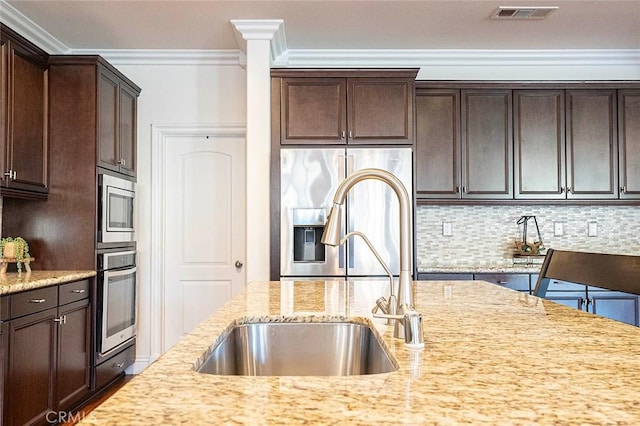 11905 Flicker Cv, Corona, CA 92883 - kitchen with stainless steel appliances, crown molding, dark brown cabinetry, light stone counters, and tasteful backsplash
