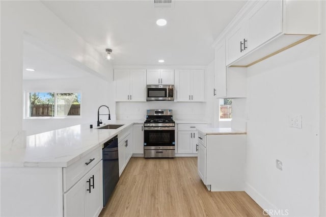 22959 Vought St, Moreno Valley, CA 92553 - kitchen featuring stainless steel appliances, light wood-type flooring, white cabinetry, a peninsula, and recessed lighting