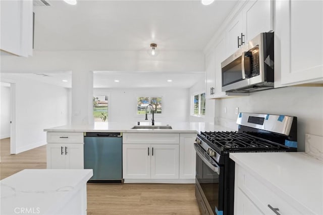 22959 Vought St, Moreno Valley, CA 92553 - kitchen featuring appliances with stainless steel finishes, light wood-style flooring, white cabinetry, a peninsula, and recessed lighting