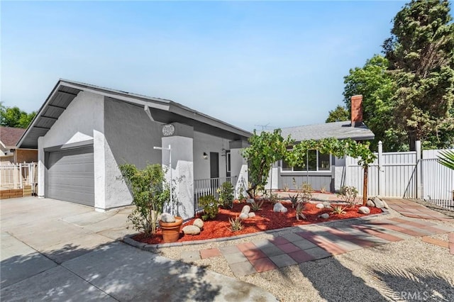 22959 Vought St, Moreno Valley, CA 92553 - view of front facade with an attached garage, driveway, stucco siding, a gate, and a chimney